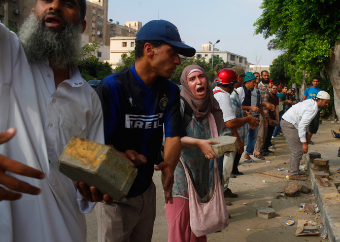 Supporters of deposed Egyptian president Mohamed Mursi help each other with bricks to build a barrier to separate them from military soldiers after clashes, in Cairo, July 8, 2013 (Reuters / Asmaa Waguih) 