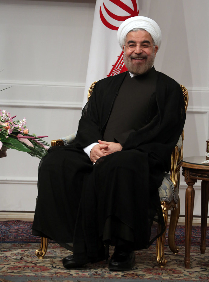 President Hassan Rowhani sits next to the national flag on his first official day in office in Tehran on August 3, 2013. (AFP Photo/Atta Kenare)