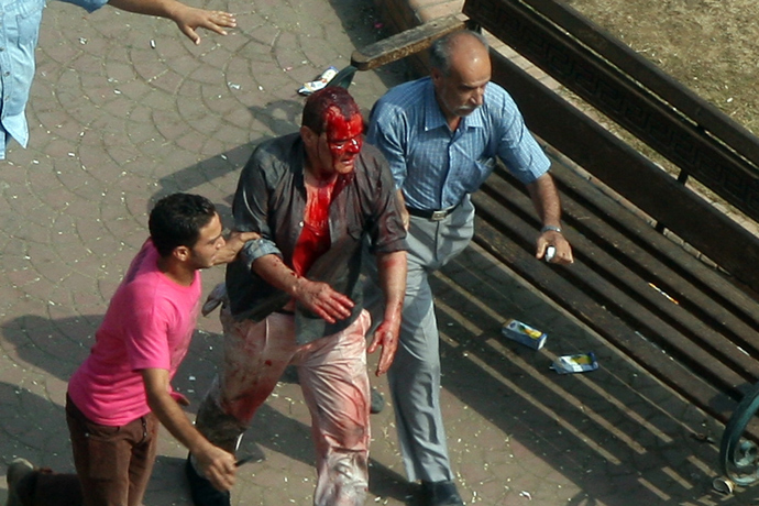 Egyptian Muslim brotherhood supporters of Egypt's ousted president Mohamed Morsi evacuate a wounded man during clashes with riot police at Cairo's Mustafa Mahmoud Square after security forces dispersed supporters Morsi on August 14, 2013 (AFP Photo / Str) 