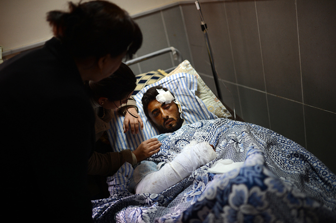 Relatives visit a Syrian Kurdish man who was injured during an airstrike on the majority-Kurdish Sheikh Maqsud district of the northern city of Aleppo (AFP Photo / Dimitar Dilkoff)