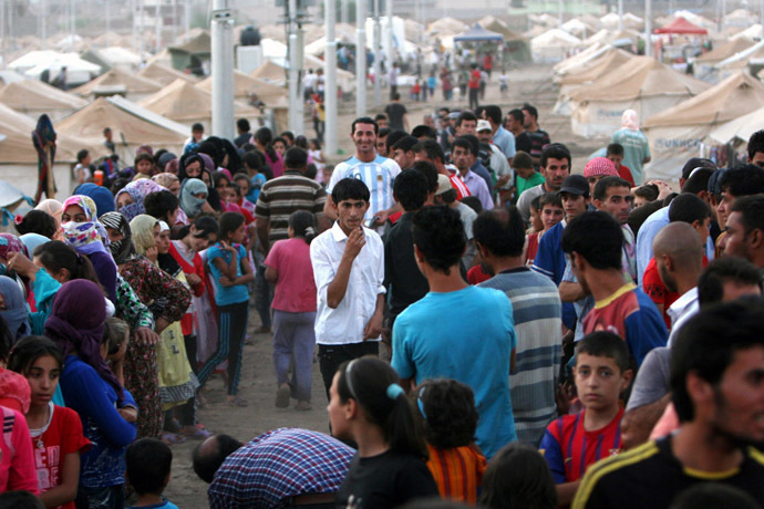 Syrian-Kurdish refugee families queue to get food at the Quru Gusik refugee camp, 20 kilometres east of Arbil, the capital of the autonomous Kurdish region of northern Iraq, on August 27, 2013. (AFP Photo/Safin) Hamed