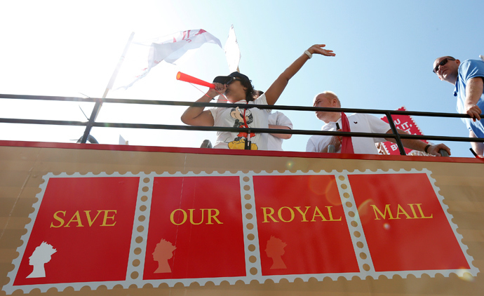Postal workers travel aboard an open top bus as they campaign against the privatisation of the Royal Mail, London (Reuters / Suzanne Plunkett)