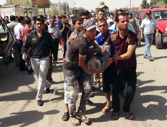 A wounded man is carried away following a suicide bombing close to the home of MP Imad Yohana in the northern city of Kirkuk on September 22, 2013, in which some 47 people were wounded including the Christian MP. (AFP Photo / Marwan Ibrahim)