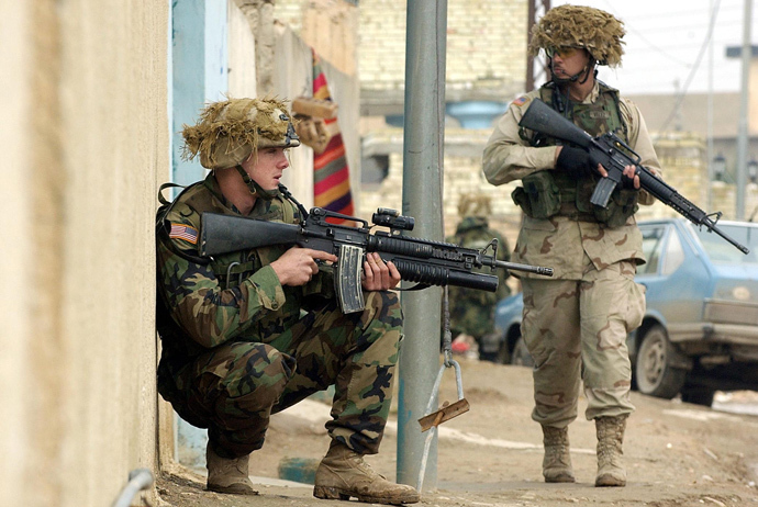 Two US soldiers from the 1st battalion, 22nd Regiment of the 4th Infantry Division secure the parameters during a foot-patrol along a street of former Iraqi dictator Saddam Hussein's hometown Tikrit, 180 Kilometers (110 miles) north of Iraqi capital Baghdad, 27 December 2003 (AFP Photo / Jewel Samad)