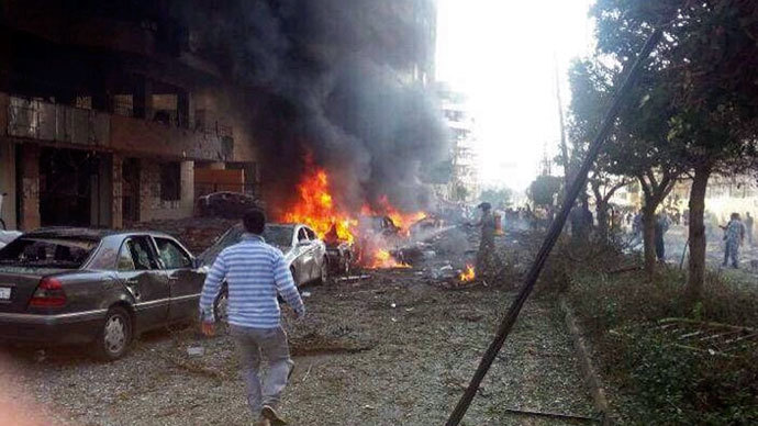 A man walks near burning cars at the site of explosions near the Iranian embassy in Beirut November 19, 2013.(Reuters / Ahmad Yassine )