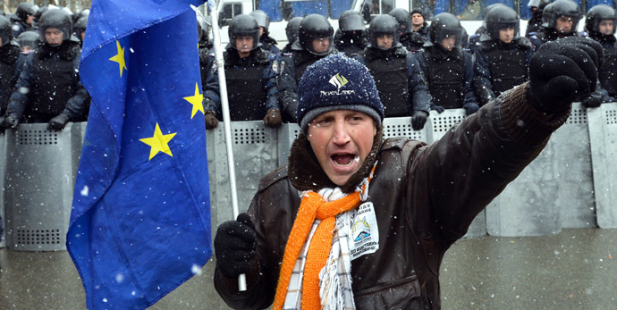 A protester with holding an EU flag shouts slogans in front of riot police during a picket held outside the presidential office in Kiev on December 7, 2013. (AFP Photo/Sergei Supinsky)