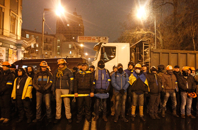 People wear helmets and masks as they line up during a rally organized by supporters of EU integration in central Kiev, December 8, 2013. (Reuters / Vasily Fedosenko)