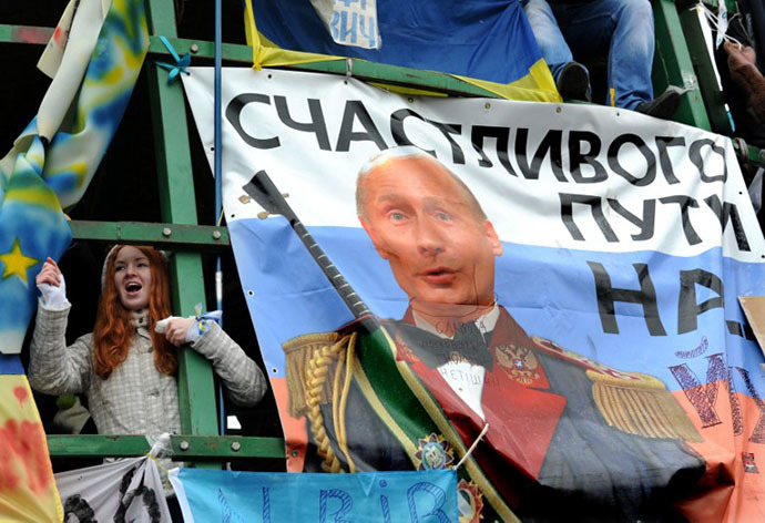 A young protester shouts slogans near a placard depicting Russian President Vladimir Putin and signed "Fare you well!" during mass rally called "The March of a Million" under the snow on Kiev's Independence Square on December 8, 2013. (AFP Photo / Sergei Supinsky)