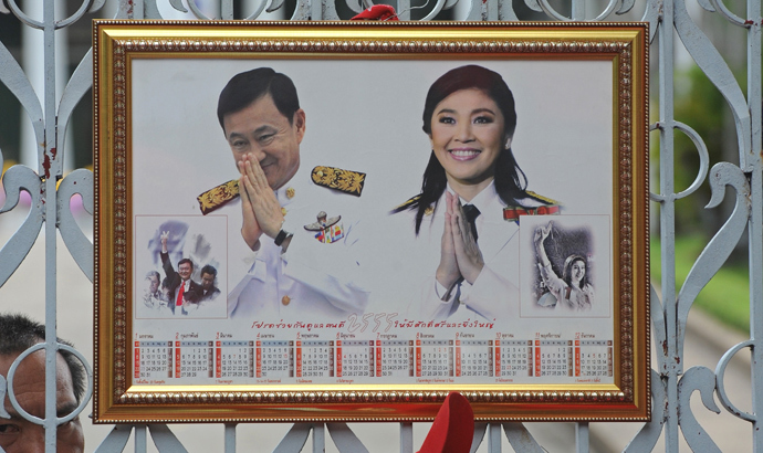 Portrait of ousted premier Thaksin Shinawatra (L) and current Thai Prime Minister Yingluck during a demonstration in front of Parliament House in Bangkok on June 7, 2012. (AFP Photo / Pornchai Kittiwongsakul)