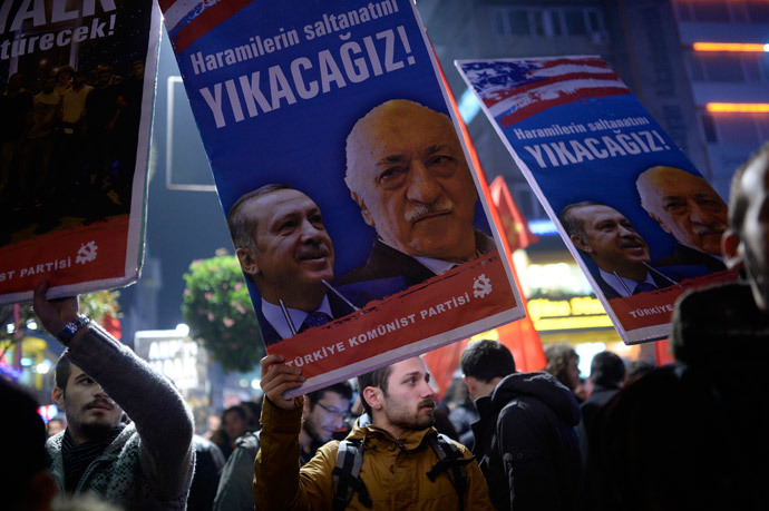 A Turkish protester holds up a placard with pictures of Turkish Prime Minister Recep Tayyip Erdogan (L) and the United States-based Turkish cleric Fethullah Gulen reading "We will cast them down" during a demonstration against corruption in the Kadikoy district of Istanbul on December 25, 2013. (AFP Photo / Bulent Kilic)