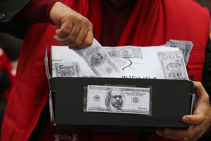 A demonstrator carries a shoe box, a symbol of the corruption scandal after police found $4.5 million secreted in shoe boxes in the home of the chief executive of Turkish state-owned Halkbank, during an anti-corruption protest in Ankara on January 11, 2014. (AFP Photo / Adem Altan)