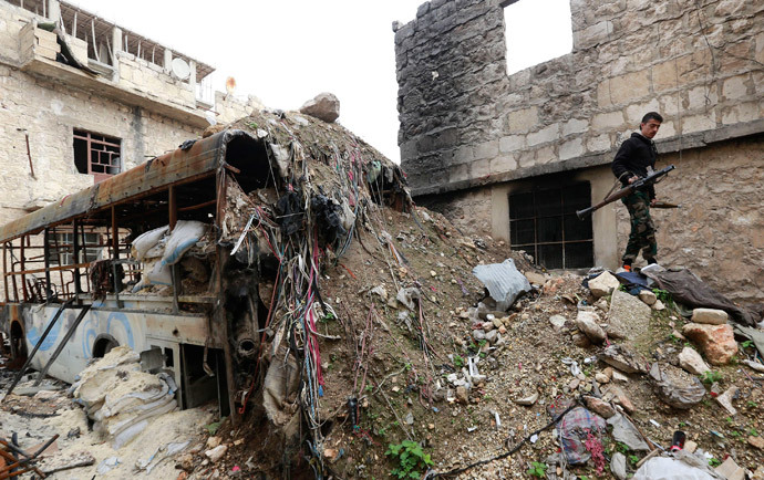 A Free Syrian Army fighter walks amid rubble as he holds a rocket launcher in Ashrafieh, Aleppo March 13, 2014.(Reuters / Hamid Khatib)