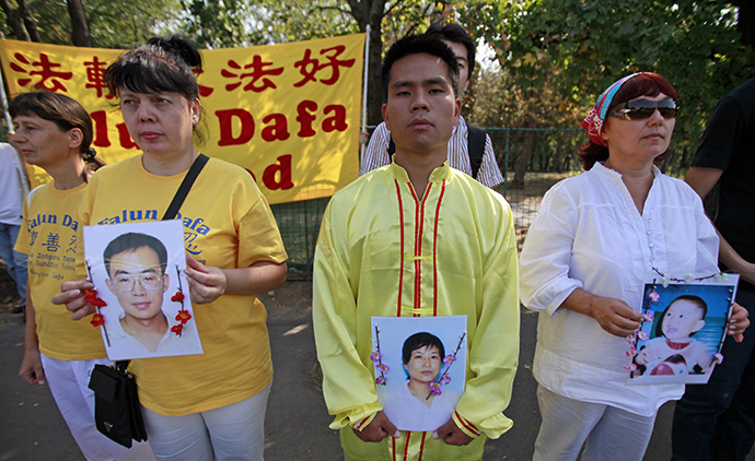 Falun Gong practitioners hold portraits of fellow Chinese practitioners as they protest against China's crackdown on Falun Gong followers in front of the Chinese embassy in Bucharest September 24, 2011. (Reuters / Radu Sigheti)