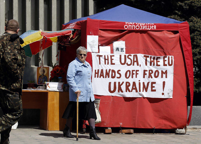 A woman walks near the information tent at the seized office of the SBU state security service in Luhansk, eastern Ukraine, April 28, 2014 (Reuters/Vasily Fedosenko)