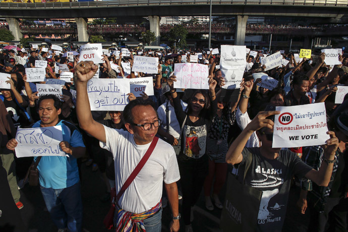 Demonstrators hold up signs during a protest against military rule at Victory Monument in central Bangkok May 24, 2014. (Reuters)