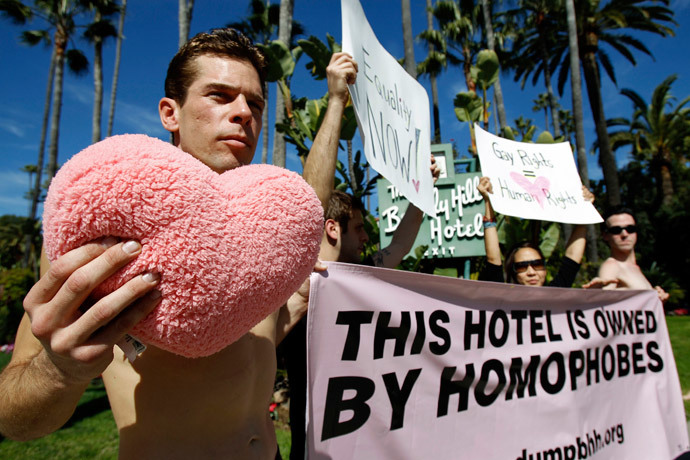 Activist Adam Raisch holds a heart-shaped pillow while staging a "love-in" to announce the boycott of the Brunei-owned Beverly Hills Hotel in Beverly Hills, California February 15, 2013. (Reuters / Mario Anzuoni)