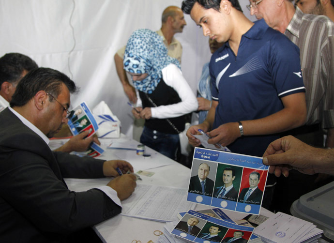 People wait in line to get their ballot papers for the presidential election at a polling centre in Damascus June 3, 2014. (Reuters)