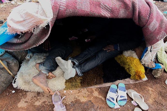 Two migrants playing cards in a tent renamed the âcasinoâ of Gurugu. Photo by @TomasoClavarino