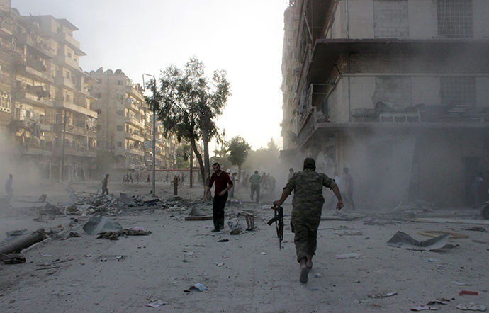 Syrians run for cover during an airstrike on the Bustan al-Qasr rebel held neighbourhood of the northern Syrian city of Aleppo on May 30, 2014 (AFP Photo / Karam Al-Masri)