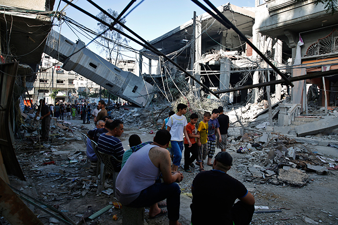 Palestinians gather near the minaret of a mosque that police said was destroyed by an Israeli Air strike in Gaza City July 30, 2014 (Reuters / Finbarr O'Reilly)