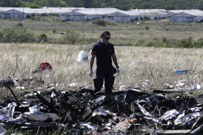 A member of a group of international experts inspects the site where the downed Malaysia Airlines flight MH17 crashed, near the village of Hrabove (Grabovo) in Donetsk region, eastern Ukraine August 1, 2014. (Reuters)