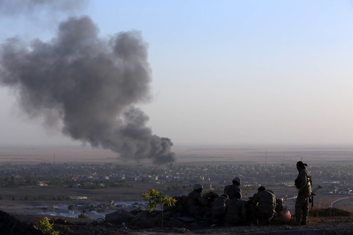 Iraqi Kurdish Peshmerga fighters look on as smoke billows from the town Makhmur, about 280 kilometres (175 miles) north of the capital Baghdad, during clashes with Islamic State (IS) militants on August 9, 2014. (AFP Photo / Safin Hamed)
