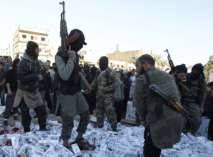 Fighters from Islamic State in Iraq and the Levant hold their weapons as they stand in the city of Raqqa (Reuters)