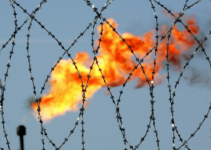 A gaz flame is seen behind a barbed wire in the Rosneft oil company production plant in Prirazlomnoye, western Siberia (AFP Photo / Tatyana Makeyeva)