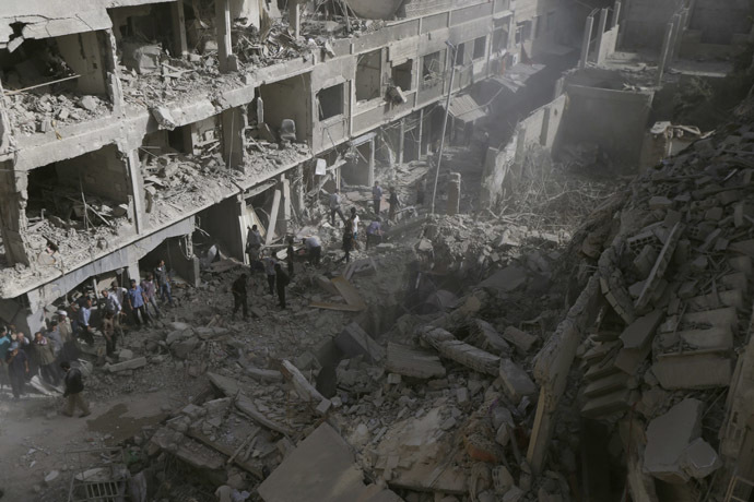 Residents inspect a damaged site after what activists say were four air strikes by forces loyal to Syria's President Bashar al-Assad in Douma, eastern al-Ghouta, near Damascus September 24, 2014. (Reuters/Bassam Khabieh)