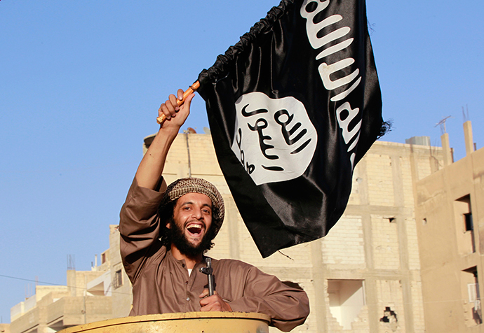 A militant Islamist fighter waving a flag, cheers as he takes part in a military parade along the streets of Syria's northern Raqqa province June 30, 2014.(Reuters / Stringer)