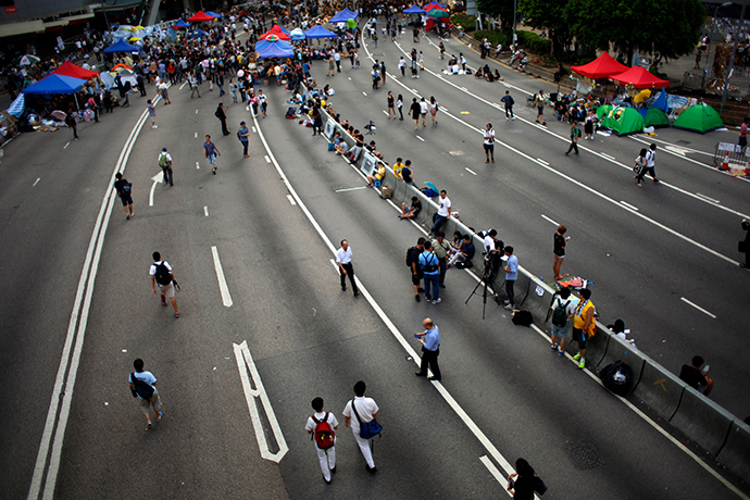 People walk near a blocked area outside the government headquarters in Hong Kong October 6, 2014 (Reuters / Carlos Barria)