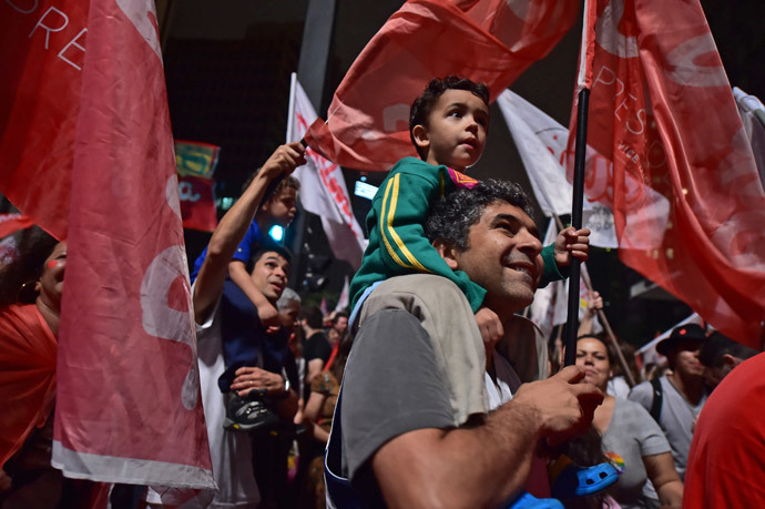 Supporters celebrate the reelection of the Brazilian President and presidential candidate for the Workers' Party (PT) Dilma Rousseff in the presidential election run-off along Paulista Avenue in Sao Paulo Brazil on October 26 2014. (AFP Photo / Nelson Almeida)