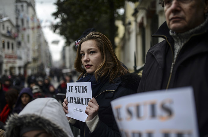 People observe a minute of silence in Istanbul on January 8, 2015 for the victims of an attack by armed gunmen on the offices of French satirical newspaper Charlie Hebdo in Paris on January 7 which left at least 12 dead and many others injured. (AFP Photo/Bulent Kilic)