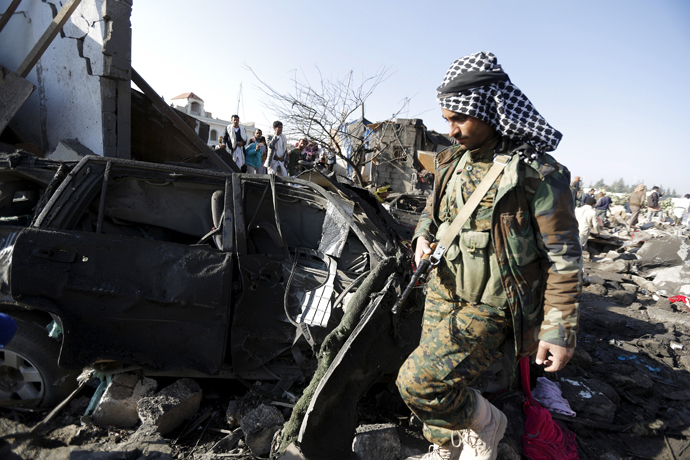 A Houthi fighter walks at the site of an air strike at a residential area near Sanaa Airport March 26, 2015. (Reuters/Khaled Abdullah)
