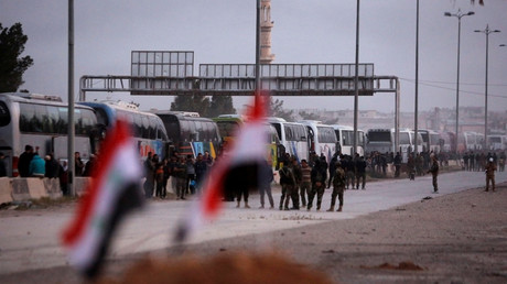 Un convoi de bus évacue des combattants armés de la ville de Harasta dans la Ghouta orientale, le 22 mars