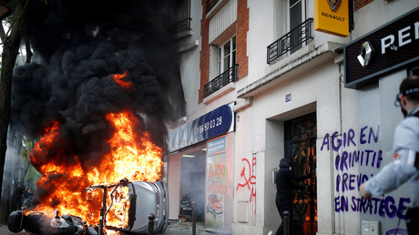 Un véhicule en feu devant la concession Renault attaquée à Paris, le 1er mai