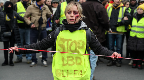 Manifestante portant une inscription contre le LBD et la GLI-F4 pendant une manifestation le 2 février.