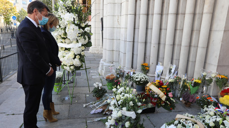 Le maire de Nice Christian Estrosi se recueille devant les fleurs déposée en hommage aux victimes de l'attaque qui a eu lieu dans la basilique Notre-Dame de l'Assomption, à Nice, le 30 octobre 2020.