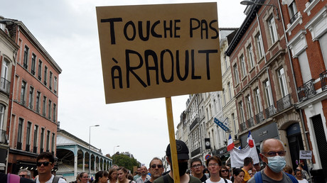 Un manifestant tient une pancarte sur laquelle on peut lire «Touche pas à Raoult» à Lille, lors d'une journée nationale de protestation contre le pass sanitaire, le 21 août 2021.