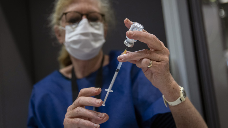 Une femme tient une seringue de vaccin contre le Covid-19