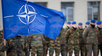 A German soldier hoists the Nato flag 