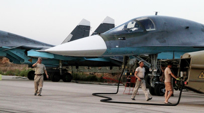 Технический персонал обслуживает российские самолеты СУ 34 в аэропорту 